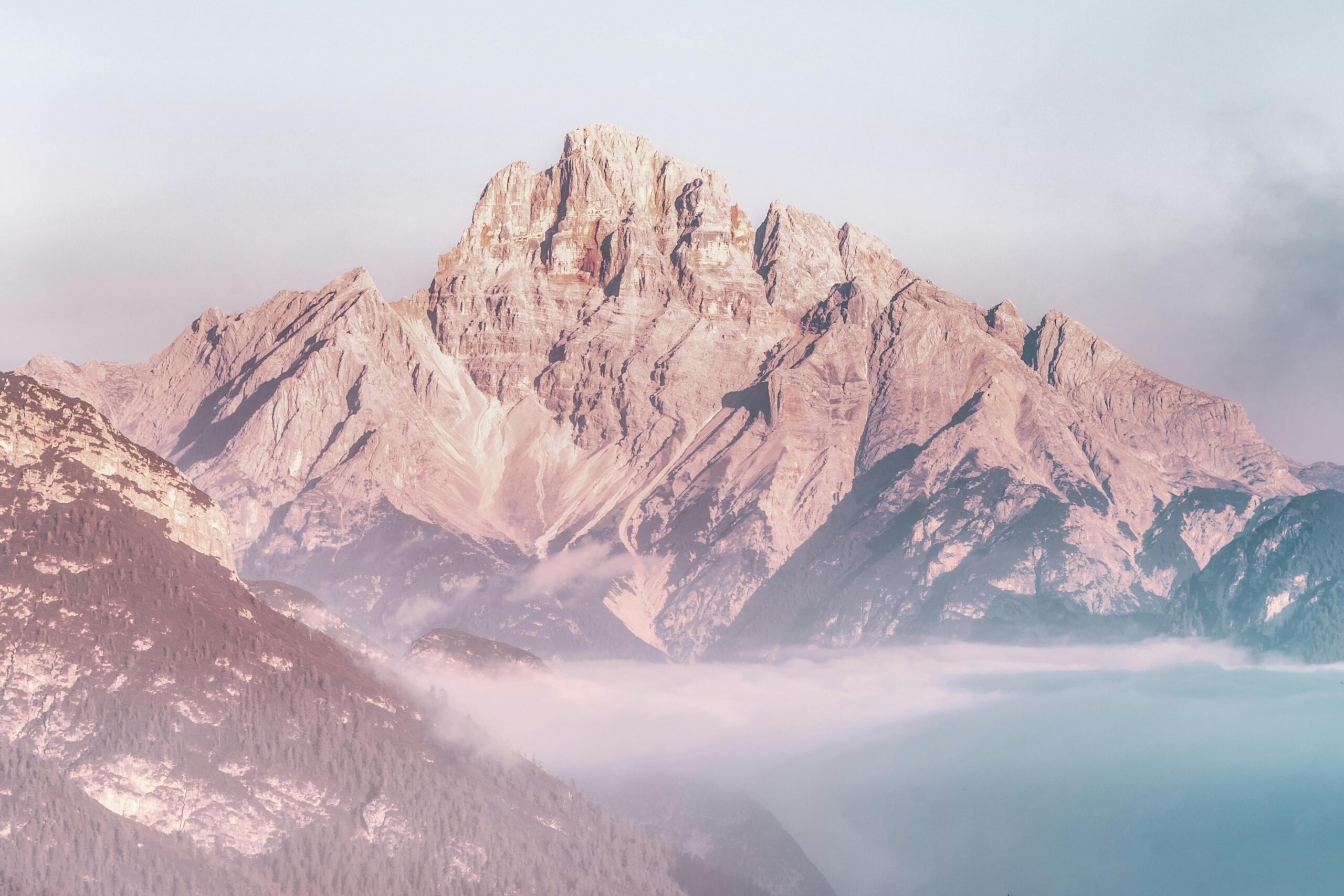 Stunning view of a sunlit mountain peak rising above the morning fog, creating a serene and majestic landscape.